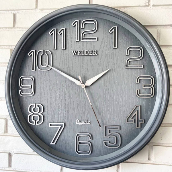 ساعت دیواری ولدر Welder، ساعت دیواری سایز 60 شماره برجسته، متریال پلاستیک بدنه، دارای فونت لاتین اعداد، دارای موتور آٰرامگرد درجه یک میتسو، عقربه های متفاوت، رنگ طوسی | مدل 630