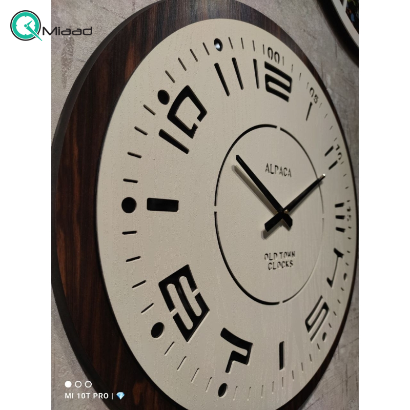 ساعت دیواری آلپاکا مدل SO10، ساعت دیواری سایز 60 با طراحی ساده و مینیمال، رنگ قهوه ای سفید، متریال MDF ساعت، صفحه با شیشه آینه ای، دارای موتور آرامگرد و دو سال ضمانت ساعت دیواری ولدر