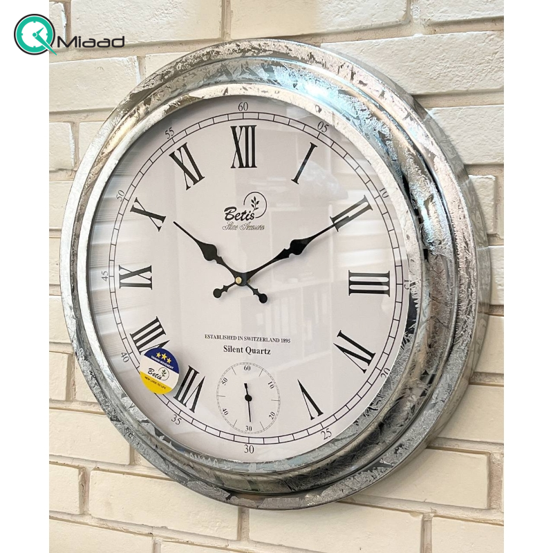 ساعت دیواری بتیس مدل 5025، ساعت دیواری بسیار مدرن با متریال فلز، رنگ آبکاری شده نقره ای، موتور تایوانی با صفحه سفید و جزییات ظریف روی صفحه، اعداد رومی، سایز 50 قیمت ساعت دیواری