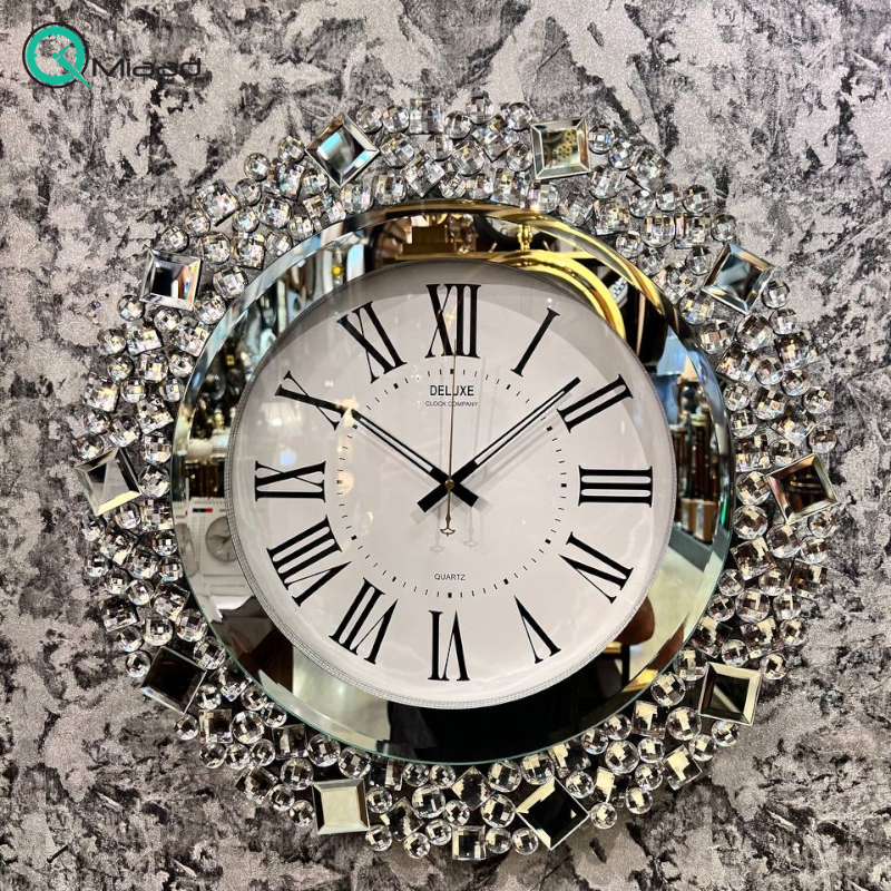 ساعت دیواری دلوکس کد 501، ساعت دیواری آیینه ای نگین دار ژورنالی برند دلوکس، صفحه سفید و اعداد رومی مشکی رنگ در صفحه ساعت، سایز 58 سانتی متر تایوانی