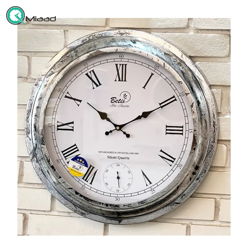 ساعت دیواری بتیس مدل 5025، ساعت دیواری بسیار مدرن با متریال فلز، رنگ آبکاری شده نقره ای، موتور تایوانی با صفحه سفید و جزییات ظریف روی صفحه، اعداد رومی، سایز 50 ساعت دیواری