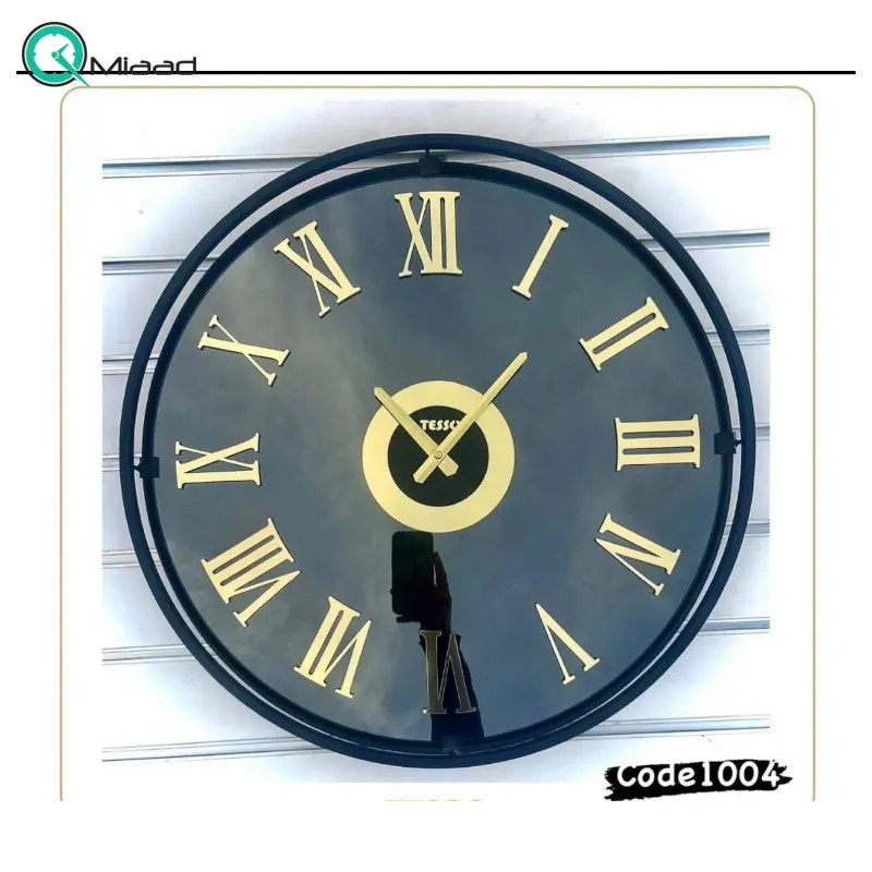 ساعت دیواری تسو مدل 1004، ساعت دیواری مدرن و ساده فلزی قطر 60 سانت با موتور آرامگرد، رنگ مشکی طلایی با آبکاری فورتیک، دارای اعداد رومی برجسته ساعت دیواری