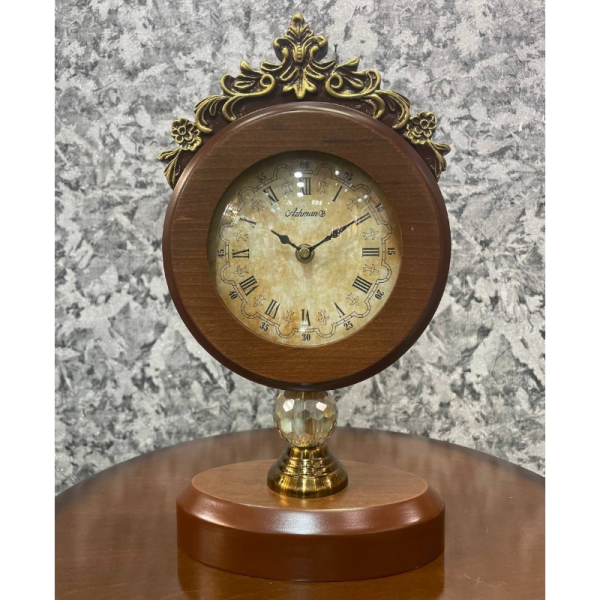 ساعت رومیزی مدل تک ستون، ساعت رومیزی با متریال چوب و فلز، دارای تنوع رنگ بندی و رنگ آبکاری مات، اعداد رومی در صفحه ساعت، ترکیب رنگ قهوه ای