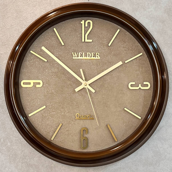 ساعت دیواری ولدر Welder مدل 100، ساعت دیواری سایز 35 با عقرب های متفاوت، دارای رنگ بندی، شماره برجسته مولتی با فونت لاتین، دارای موتور درجه یک میتسو، رنگ قهوه ای