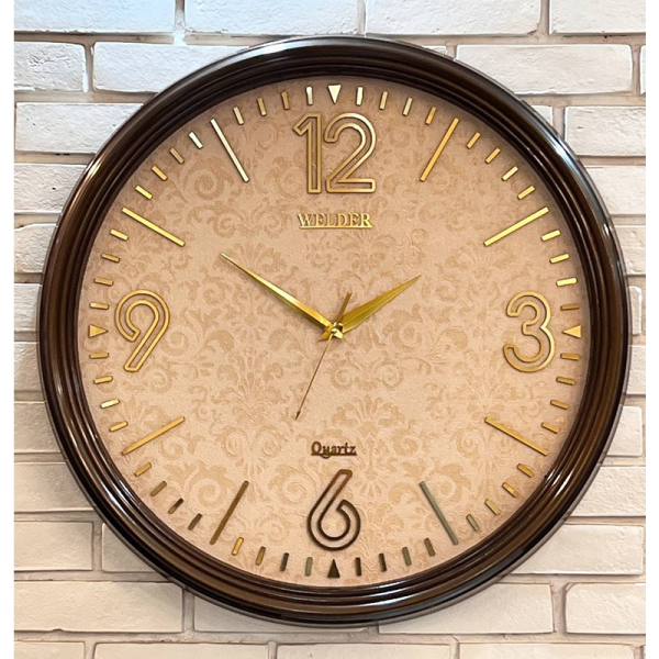 ساعت دیواری ولدر Welder مدل 7012، ساعت دیواری سایز 70 با عقرب های متفاوت، دارای رنگ بندی، شماره برجسته مولتی با فونت لاتین، دارای موتور درجه یک میتسو، رنگ قهوه ای