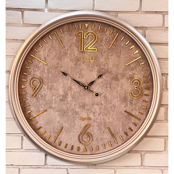 ساعت دیواری ولدر Welder مدل 7012، ساعت دیواری سایز 70 با عقرب های متفاوت، دارای رنگ بندی، شماره برجسته مولتی با فونت لاتین، دارای موتور درجه یک میتسو، رنگ طوسی