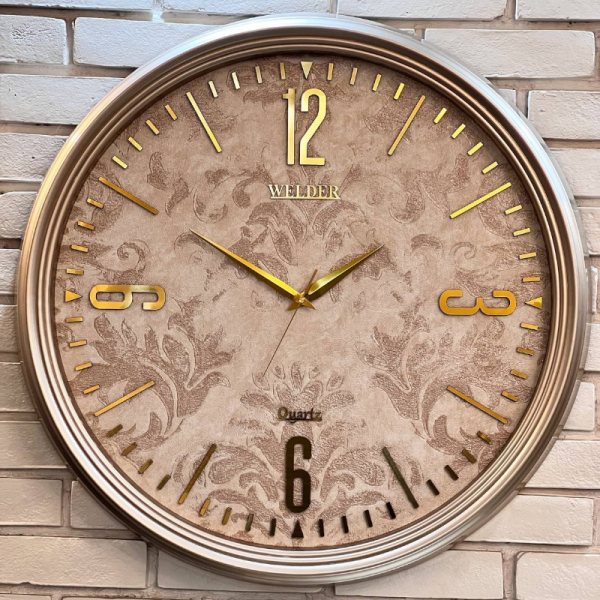 ساعت دیواری ولدر Welder مدل 7014، ساعت دیواری سایز 70 با عقرب های متفاوت، دارای رنگ بندی، شماره برجسته مولتی با فونت لاتین، دارای موتور درجه یک میتسو، رنگ طوسی
